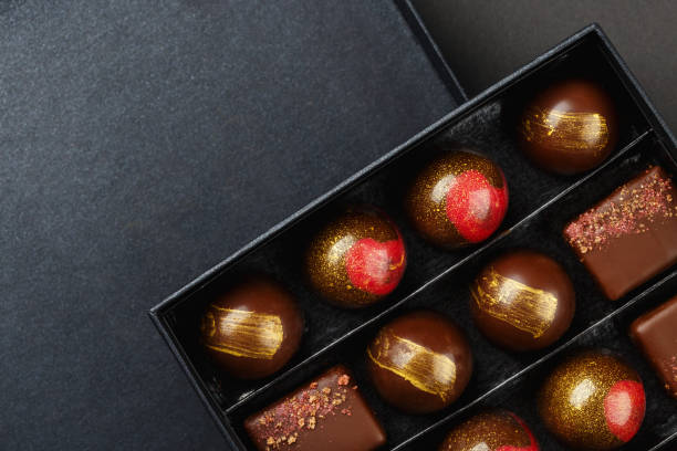 set of luxury handmade bonbons in box on black background - craft chocolate candy black box imagens e fotografias de stock