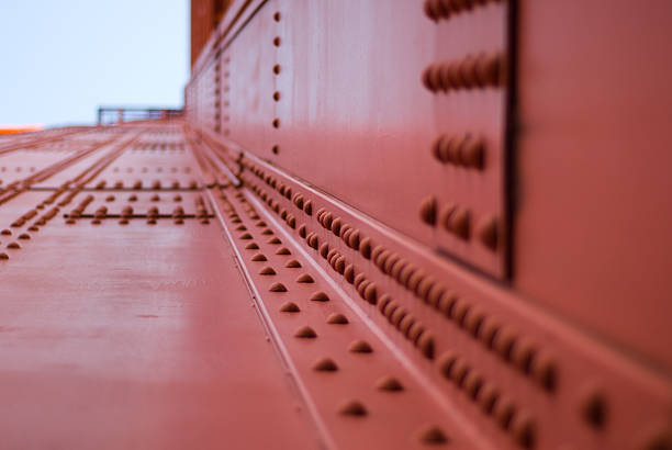 Detailed view of a Golden Gate Bridge, highlighting its industrial design. The textured surface and soft focus create an abstract perspective, emphasizing architectural elements.