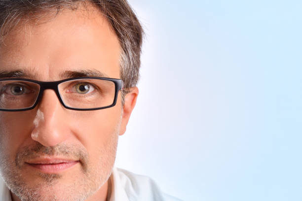 Attractive middle-aged man with eyeglasses and white shirt blue background detail. Concept of visual correction with glasses. Horizontal composition