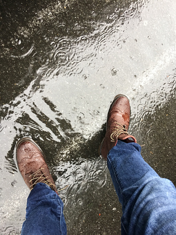 entreprenør Direkte Højde Hard Working Man Wearing Jeans And Boots Standing On A Water Filled Road  During An Unexpected Rain Storm Stock Photo - Download Image Now - iStock