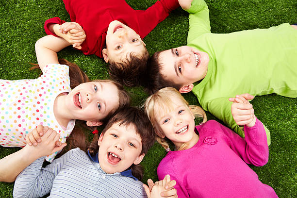 istock A group of happy children lying on grass 104121811