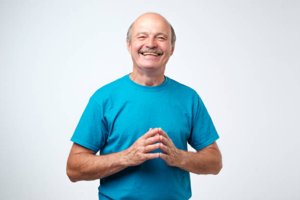 Portrait of a handsome senior man in blue t-shirt laughing stock photo