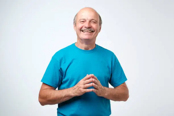 Photo of Portrait of a handsome senior man in blue t-shirt laughing