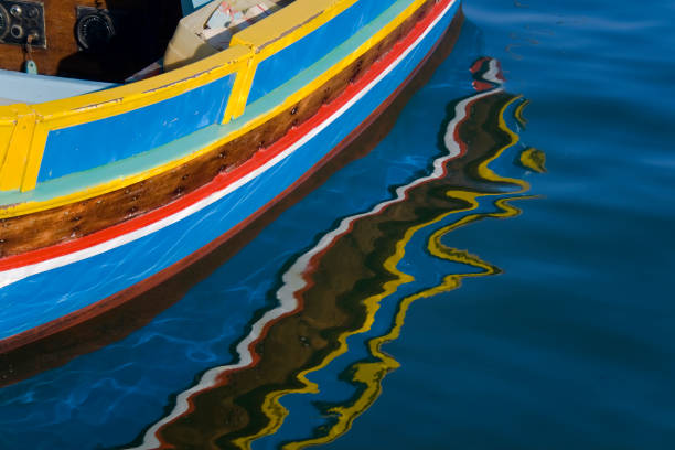 A colourful upside down rowboat on a dock being repaired at a small fishing port.