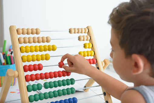 Cute little child learnning to count on the abacus
