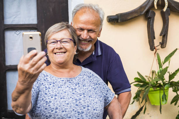 senior ältere ehepaar im ruhestand haben eine video-chat-konferenz mit den eltern, die weit weg wohnen. erwachsene lernen, technologie nutzen, um moderne und leben besser werden. tech-art zu kommunizieren mit freunden mit internet-video - family domestic life senior adult computer stock-fotos und bilder