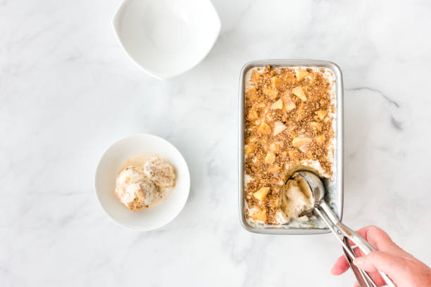 istock Hand Scooping Ice Cream with Apples, Caramel Sauce and Crumbles 1041237338