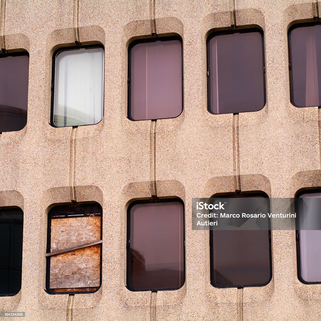 Windows assortment! One is boarded up Monotonic building with identical windows, each one under a different light condition and showing a different reflection. Architecture Stock Photo