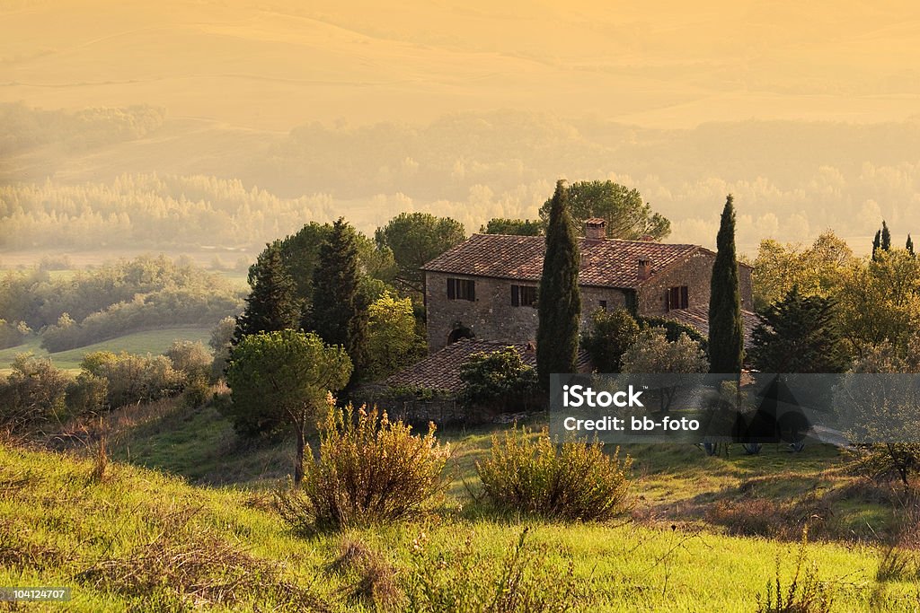 Tuscany Stone hose on a green grass hill House in the Tuscany Agricultural Field Stock Photo