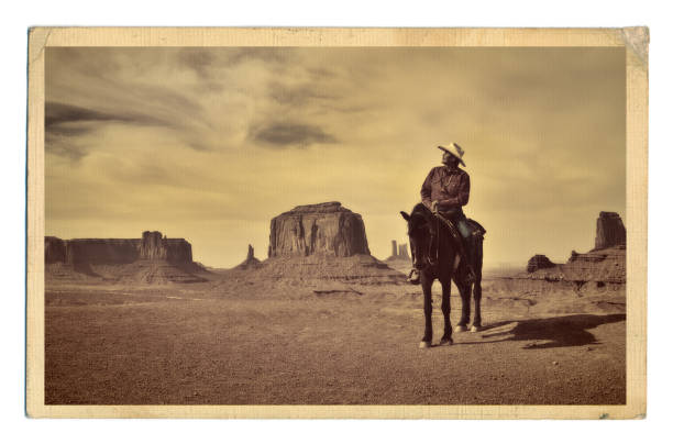Retro Photo of Western Cowboy Native American with Horse at Monument Valley Tribal Park A retro style photo of a native American cowboy and his horse at the edge of a butte cliff at the Monument Valley Tribal Park in Arizona, USA. A famous tourist destination in the southwest USA. The iconic western landscape is a backdrop for many western movies. The native American is a Navajo tribe native. Photographed on location in sepia tone. archival stock pictures, royalty-free photos & images