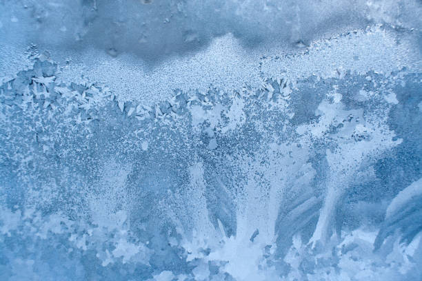 istock Blue frozen winter window with beautiful icy pattern. 1041252518