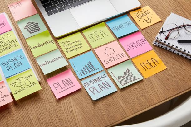 high angle view of paper stickers with business strategy and laptop on tabletop stock photo