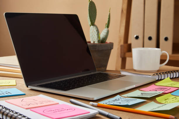 istock laptop with blank screen and paper stickers and cactus on tabletop 1041260466