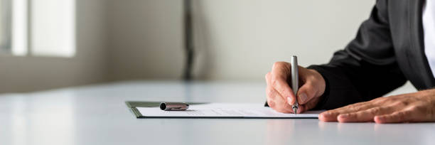 wide panorama view of businessman hand signing legal or insurance document - endorsing business application form filling imagens e fotografias de stock