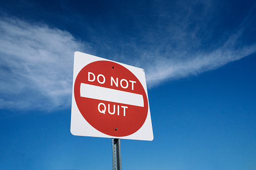 Motivational road sign concept to never give up and don't quit