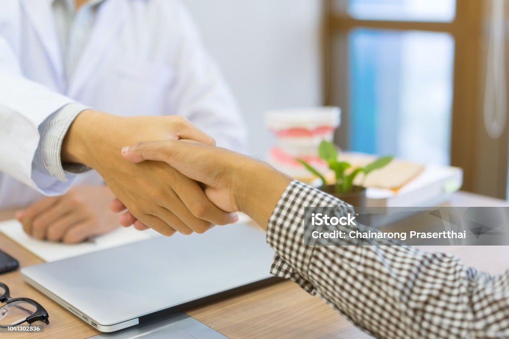 Nahaufnahme der Zahnarzt Hand Shake mit Patienten nach beraten und diagnostizierten Zähnen-Syndrom am Schreibtisch mit medizinischen Zahnmedizin Konzept - Lizenzfrei Zahnarzt Stock-Foto