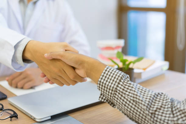 close up dentist hand shake with patient after give advice and diagnosed of teeth syndrome at office desk with , medical dentistry concept close up dentist hand shake with patient after give advice and diagnosed of teeth syndrome at office desk with , medical dentistry concept dental equipment hand stock pictures, royalty-free photos & images