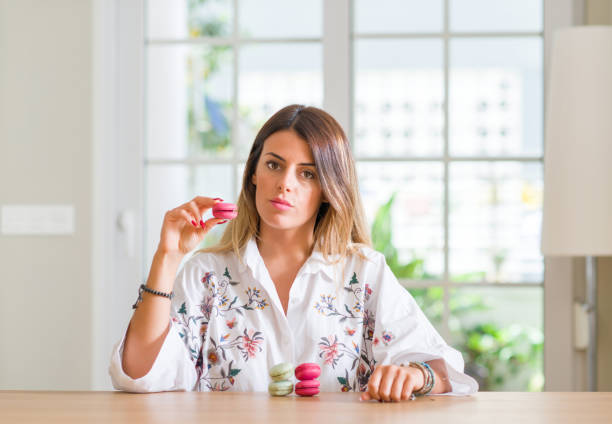 istock Young woman at home eating macarons with a confident expression on smart face thinking serious 1041304962