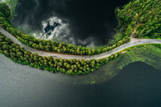 Road on a narrow piece of land between two lakes with forest Road on a narrow piece of land between two lakes seen from the air at Punkaharju ridge Finland narrow stock pictures, royalty-free photos & images