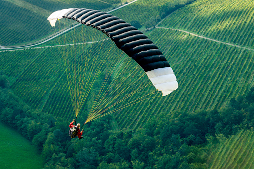 Gliding with a parachute on the background of bright sunset.