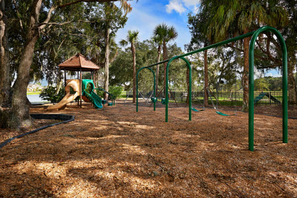 A Shade Covered, Wood Chip Playground situated by Trees stock photo