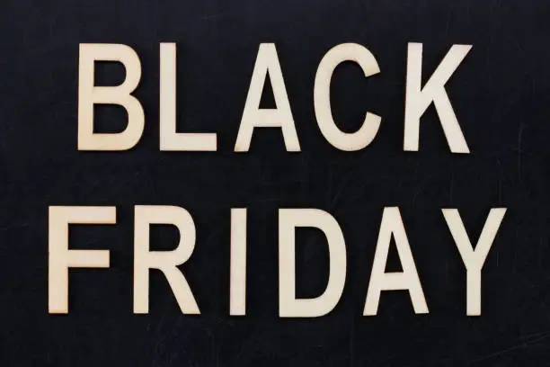 Photo of black Friday - text in wooden letters on blackBoard. Copy space
