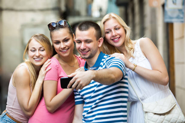 istock Four young cheerful persons taking self picture 1041340706