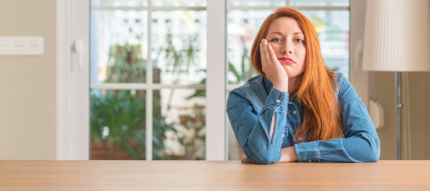 istock Redhead woman at home thinking looking tired and bored with depression problems with crossed arms. 1041345830
