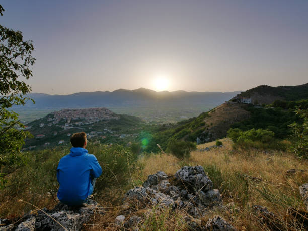 istock Young man watching sunrise over Teggiano 1041359014