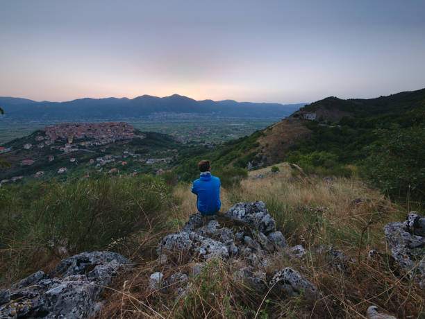 istock Young man watching sunrise over Teggiano 1041359074