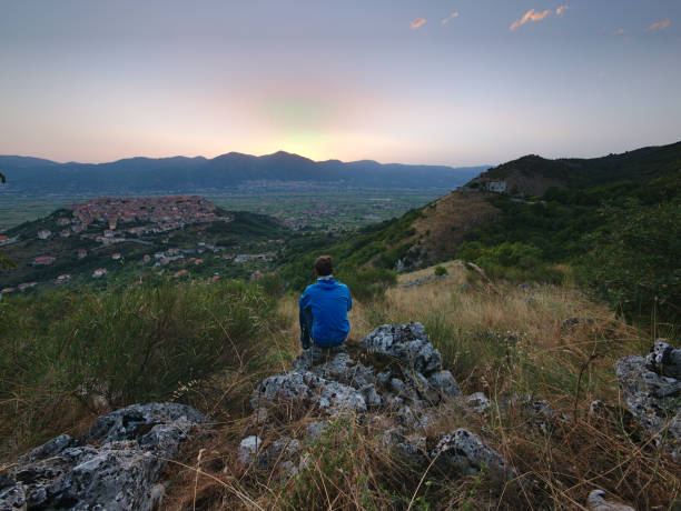 istock Young man watching sunrise over Teggiano 1041359118