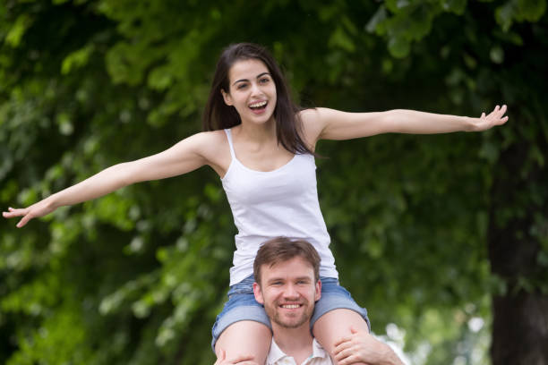 istock Excited girlfriend sit on boyfriend shoulders stretching hands 1041360726