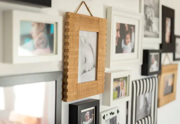 white wall with photos of the family in various photo frames