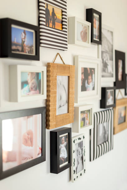 photos of the family in various photo frames white wall with photos of the family in various photo frames family photo on wall stock pictures, royalty-free photos & images