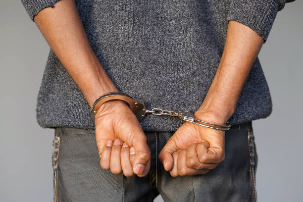 istock Criminal hands locked in handcuffs. Close-up view 1041383946