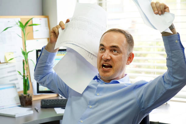 istock Businessman at his desk throws documents and papers into the air 1041389258