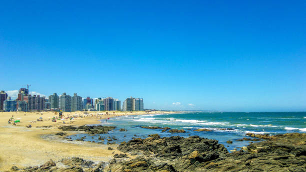 praia brava, na cidade de punta del este, no uruguai. - cloud sea beach umbrella sky - fotografias e filmes do acervo