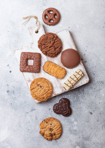 istock Oat and chocolate cookies selection on wooden board on stone kitchen table background. 1041404082