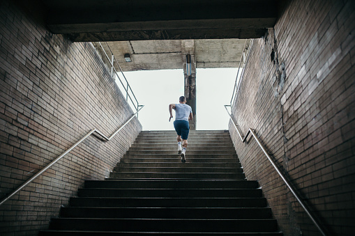 Young male athlete running up the stairs