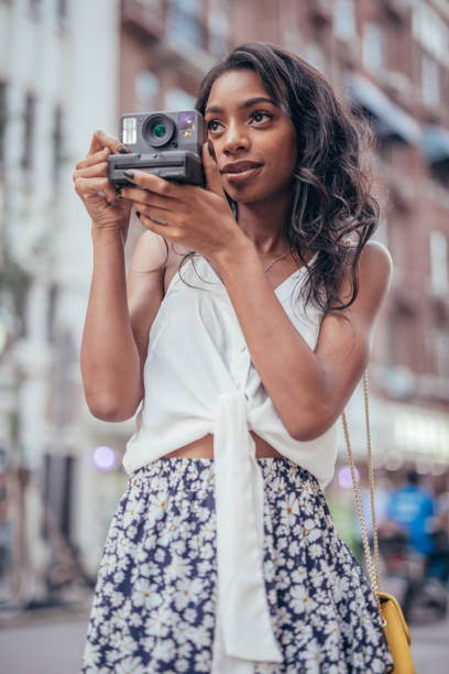 istock Woman holding polaroid camera 1041445676