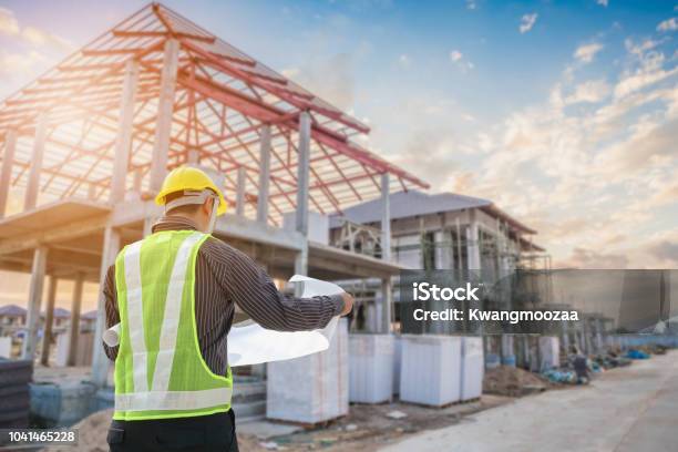 Professional Engineer Architect Worker With Protective Helmet And Blueprints Paper At House Building Construction Site Stock Photo - Download Image Now
