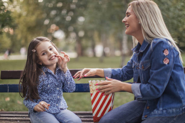 istock Mother and daughter eating popcorn 1041467564