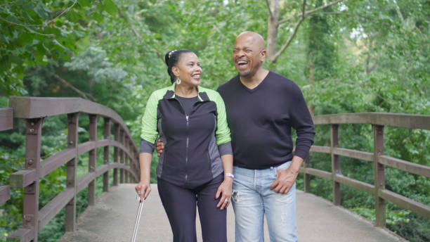 una coppia che cammina e si gode la natura insieme - senior adult senior couple exercising african ethnicity foto e immagini stock