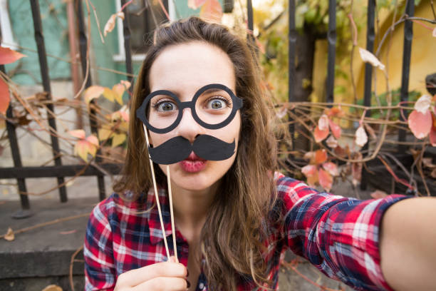 Mustache selfie Girl making a selfie with fake moustaches and fake eyeglasses. women movember mustache facial hair stock pictures, royalty-free photos & images