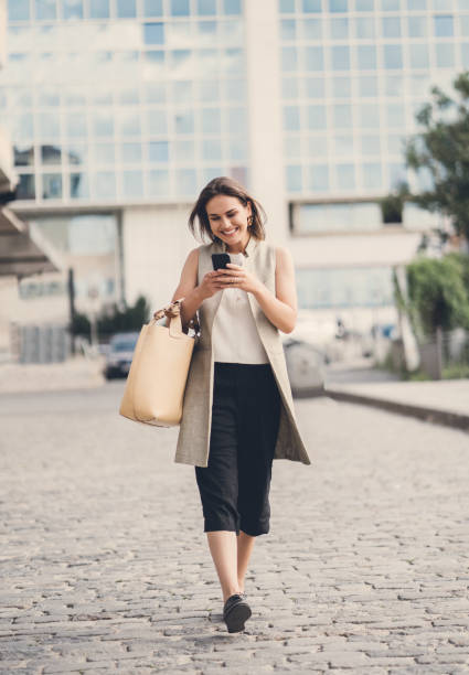 istock Young happy woman walking and texting 1041475536