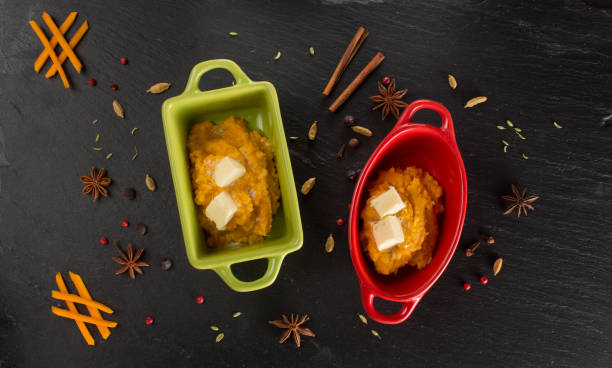 Pumpkin porridge with millet, butter in original, stylish ceramic forms on the black chalkboard,shale stone with indian spices and herbs.Bio asian healthy food ingredients or cookingconcept. Close up, space for text,flat lay,top view papilla de calabaza con mijo, mantequilla de cerámica original, con estilo forma en la pizarra negra, pizarra piedra con hierbas y especias de la india. bio asia alimentos saludables ingredientes o cookingconcept. cierre, espacio para texto, endecha plana