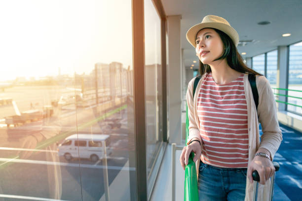 istock asian tourist standing next to large windows. 1041482256