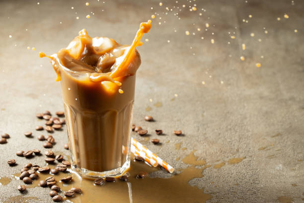 istock Iced latte coffee splash with ice cubes and roasted beans on a dark background. With copy space 1041489700