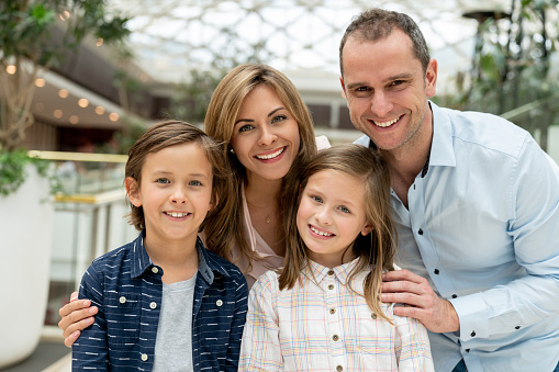 Portrait of a loving family at the shopping center looking at the camera smiling - lifestyle concepts