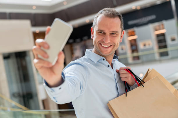 istock Shopping man taking a selfie at the mall 1041492668